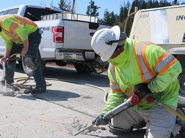 Workers breaking concrete with jackhammers