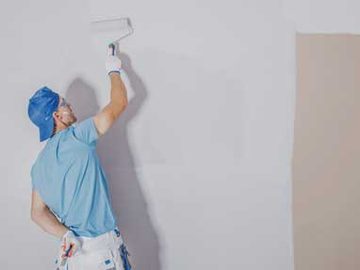 Painter rolling a finish coat on an interior wall